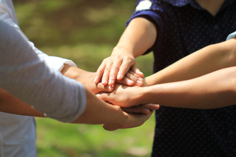 Meeting teamwork concept,Friendship,Group people with stack of hands showing unity on natural green background